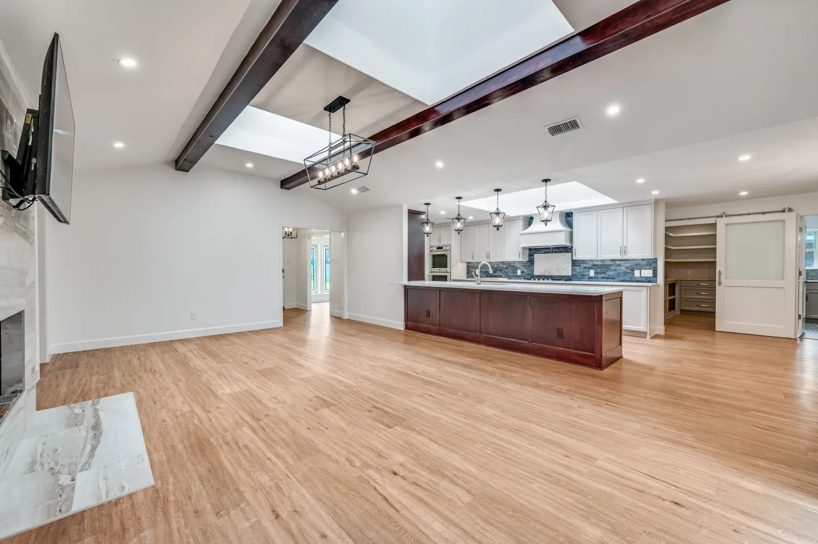 Open-concept living and kitchen renovation with exposed beams