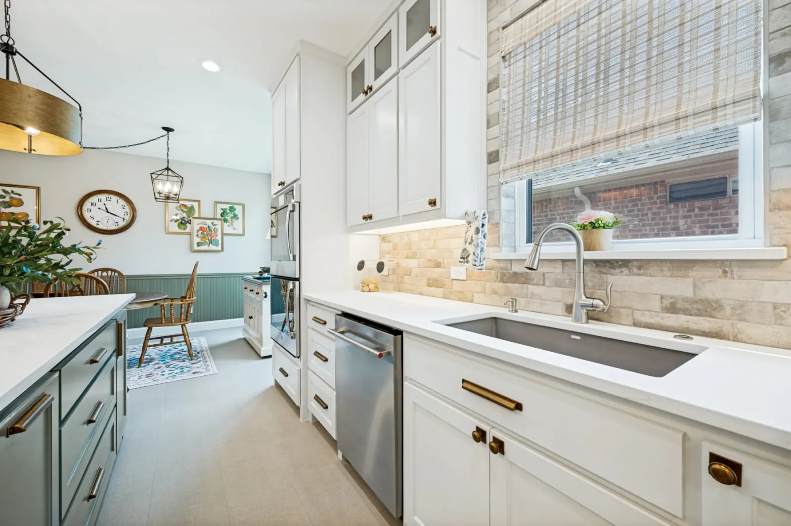 Bright white kitchen with brass hardware and breakfast nook