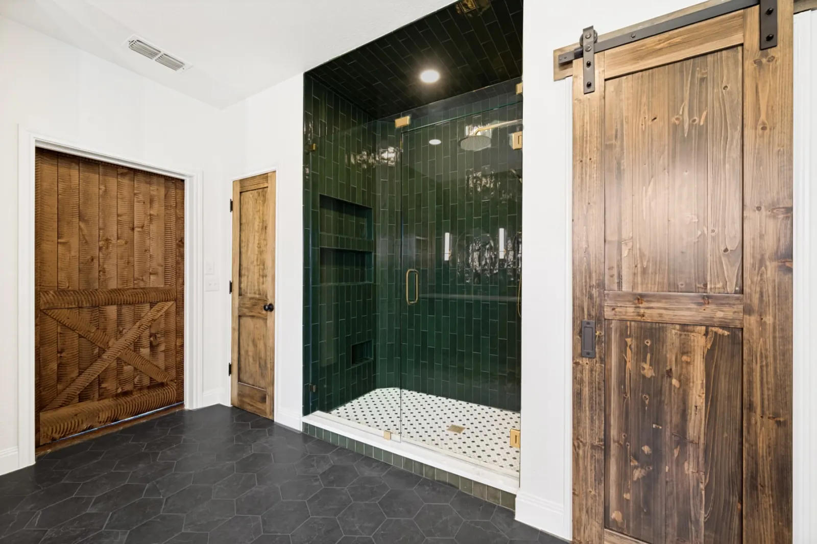 Emerald green tile walk-in shower with rustic walnut barn door