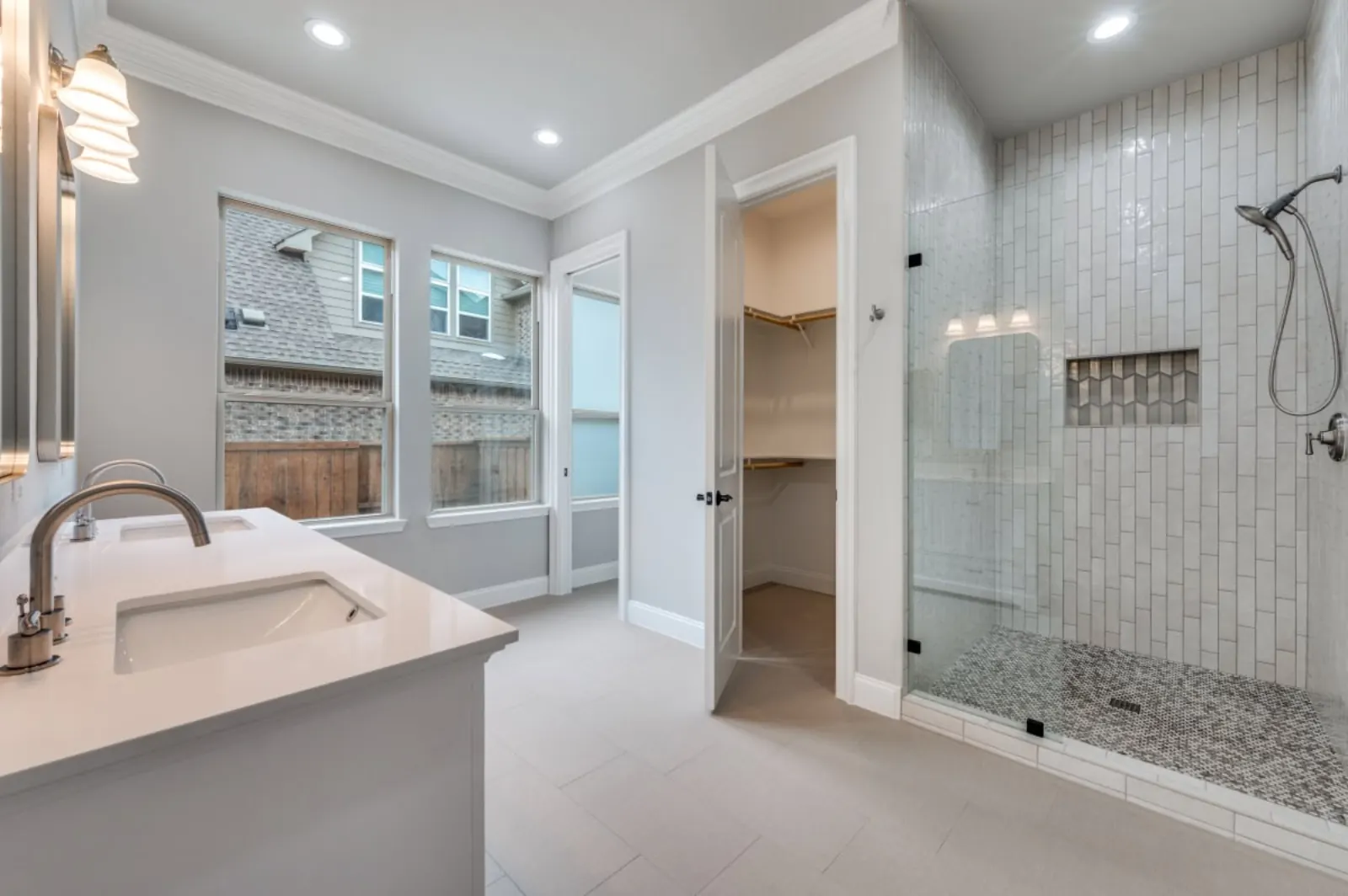 Spa-style bathroom with vertical white subway tile shower and pebble floor